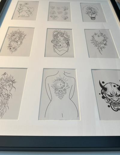 Photo d'un cadre avec les dessins proposés en tant que tatouage par David Delaunay, tatoueur à La Folie Douce Tattoo à Saint-Lumine-de-Clisson.